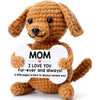 A handcrafted crochet dog doll in brown yarn with a white heart-shaped tag that reads I love you fur-ever and always