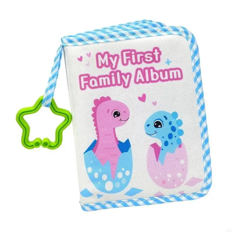 A pink cloth baby photo album with a blue striped ribbon and a dinosaur illustration.