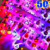 A hand holds a sheet of glow rings featuring Halloween themed skulls, bats, and pumpkins under purple light.
