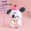 A white and black cartoon puppy cake topper with pink accents and a red nose, shown against a light pink background.
