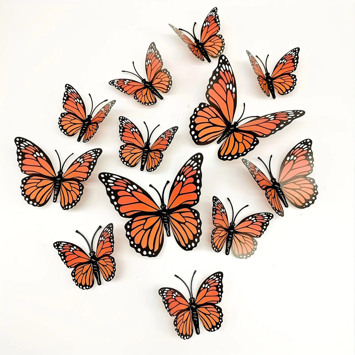 A set of twelve orange and black monarch butterfly decals scattered on a white background.