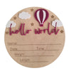 A natural wood birth announcement plaque shaped like a hot air balloon with clouds and stars, featuring the text hello world.