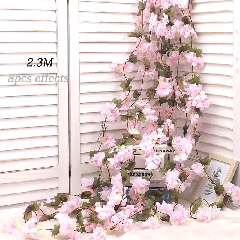 Artificial sakura flower garland with pink blossoms draped against a white slatted background