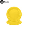 A stack of ten 7-inch yellow disposable paper plates.