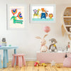A framed art display featuring colorful illustrations of a unicorn, a giraffe, and an owl on a white background.