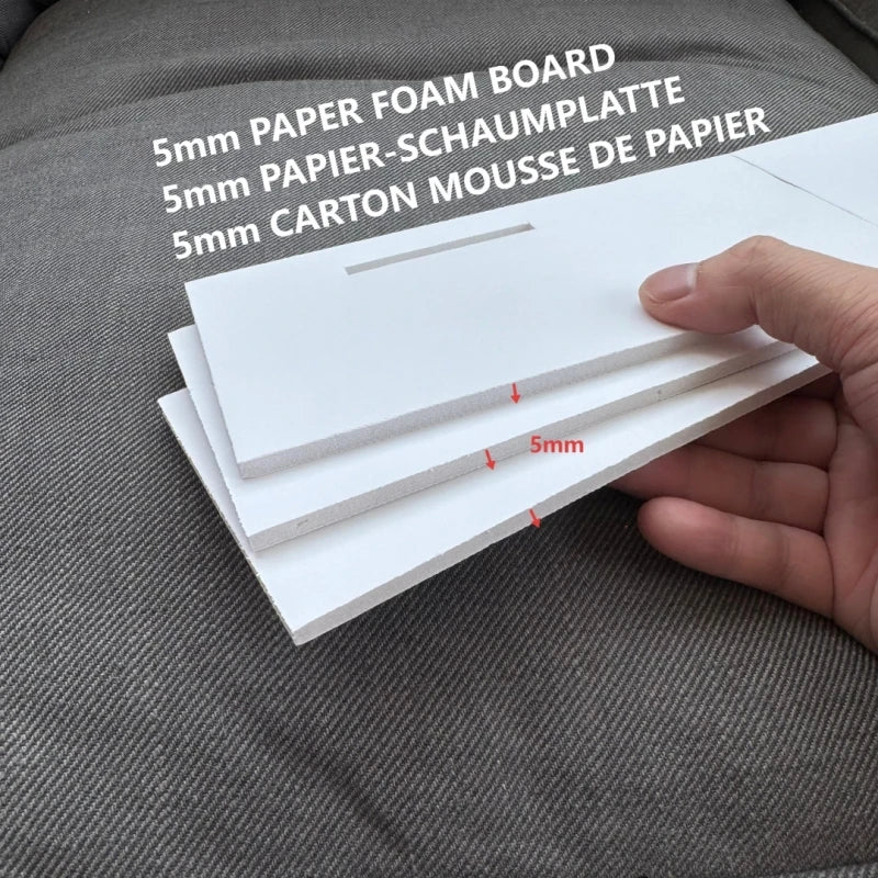 A hand holds several white 5mm paper foam boards for crafting or party decor.
