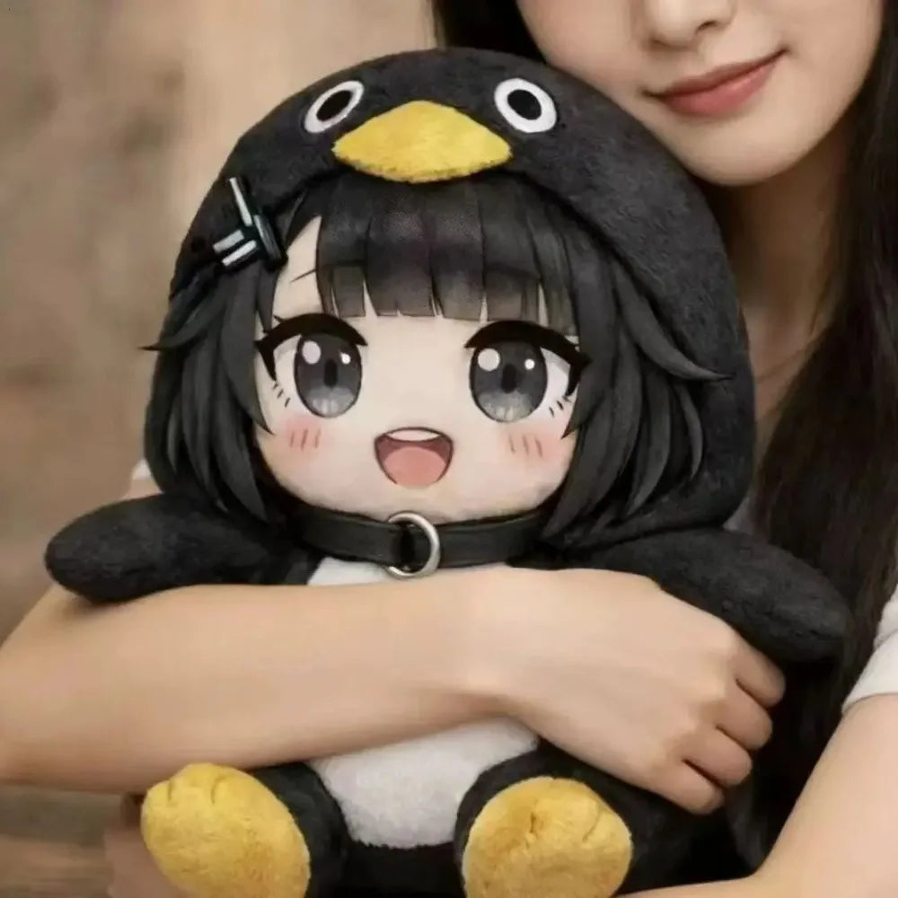 A woman is holding a cute black penguin plush doll with yellow accents.
