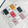 A collection of various square and rectangular grid binders and storage items for photocard collections arranged on a white t