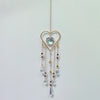 A delicate gold heart pendant featuring a clear crystal gemstone and multiple dangling crystal beads.