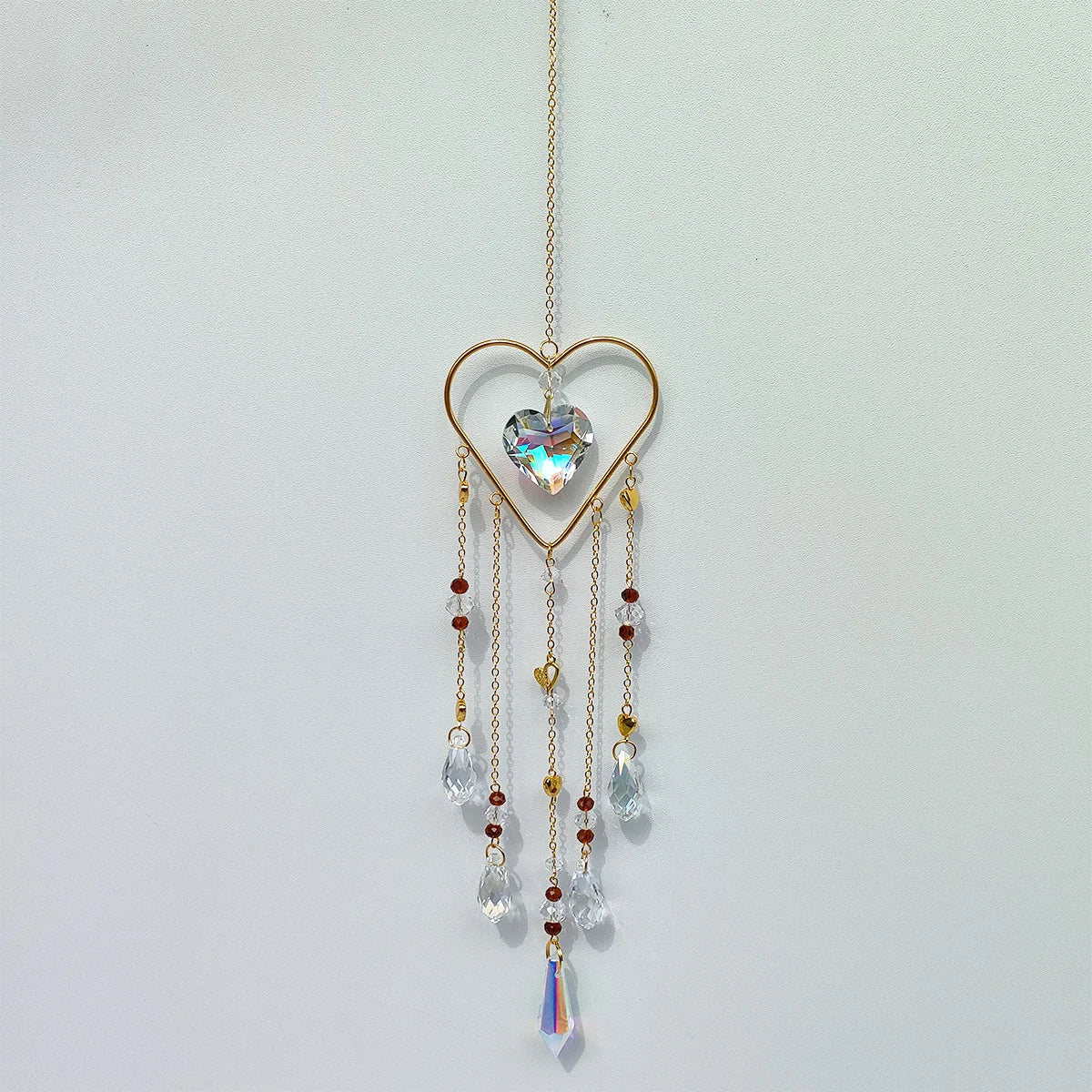 A delicate gold heart pendant featuring a clear crystal gemstone and multiple dangling crystal beads.