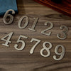 Magnetic silver numbers 6012345789 arranged on a wooden surface