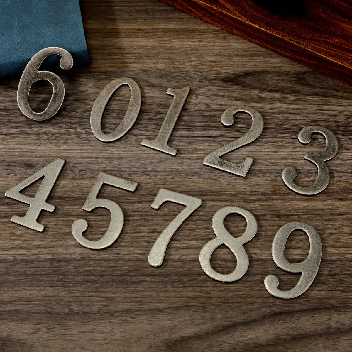 Magnetic silver numbers 6012345789 arranged on a wooden surface