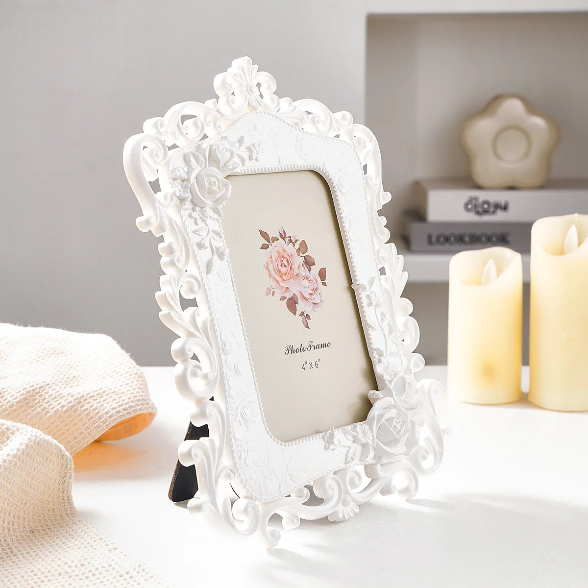White resin photo frame with intricate floral detail displayed on a white surface.