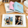 A pink and blue window photocard album with a white photo inside, next to a pink and blue heart-shaped box.