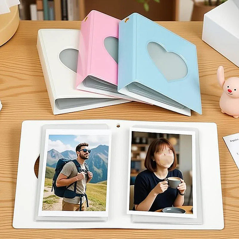 A pink and blue window photocard album with a white photo inside, next to a pink and blue heart-shaped box.