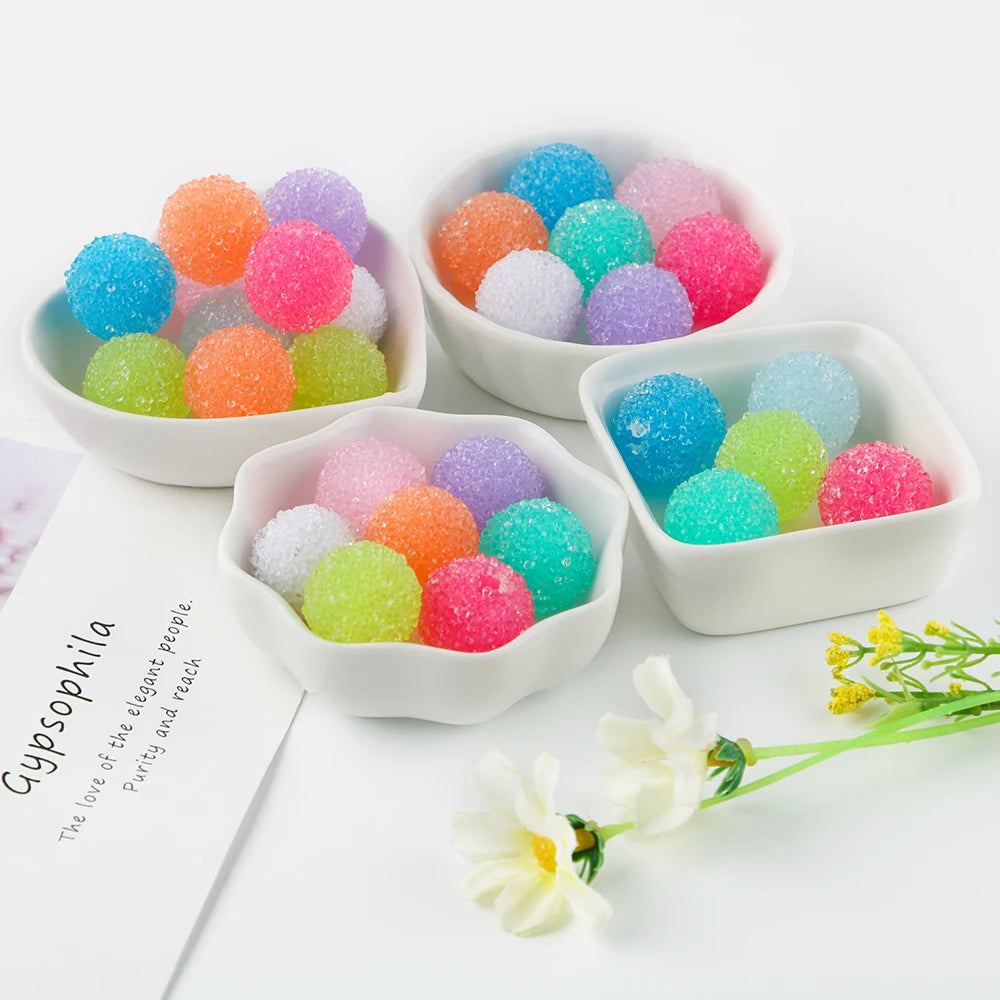 A set of ten textured resin beads in various pastel colors are displayed in white bowls.