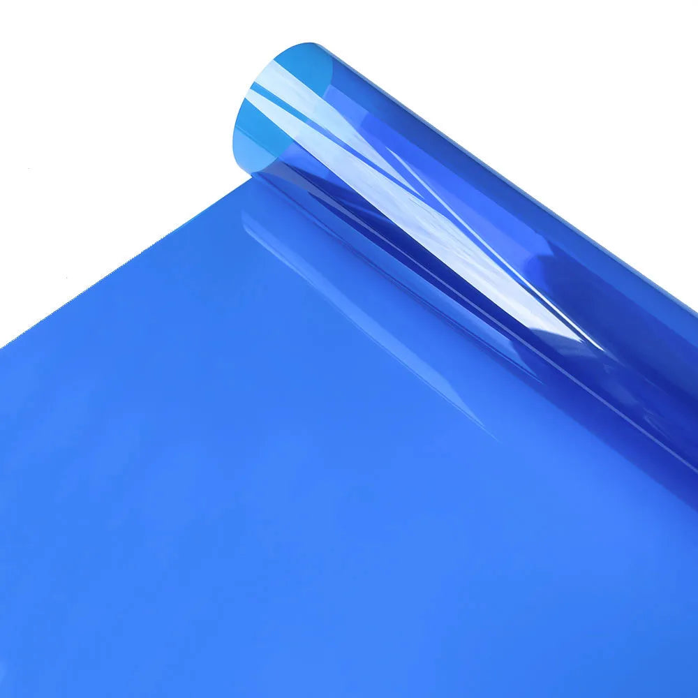 A close-up of a bright blue decorative stained glass window film rolled on a blue surface.