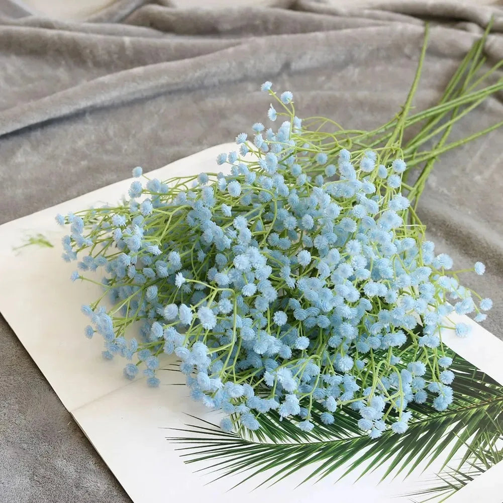 A bouquet of light blue artificial gypsophila flowers displayed on a white surface.