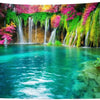 A panoramic tapestry featuring lush green and pink waterfalls cascading down a cliff face into a vibrant turquoise pool.