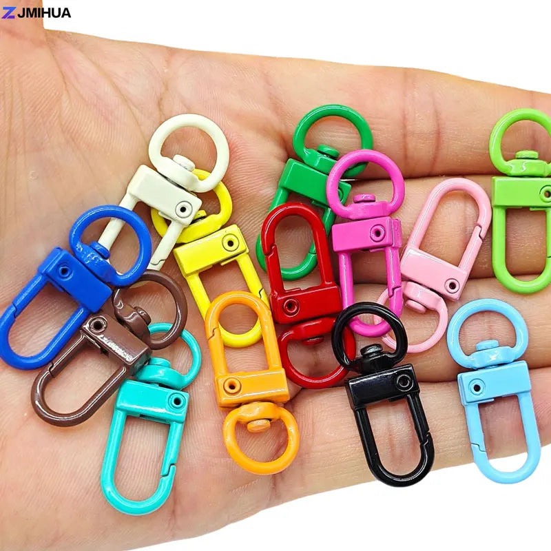 A hand displays various colorful lobster clasp hooks for jewelry making and DIY crafts.