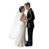 A wedding cake topper featuring an elegant bride and groom figurine in white and black attire.