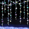 Iridescent mermaid and jellyfish party streamers hanging down over sparkling blue glitter