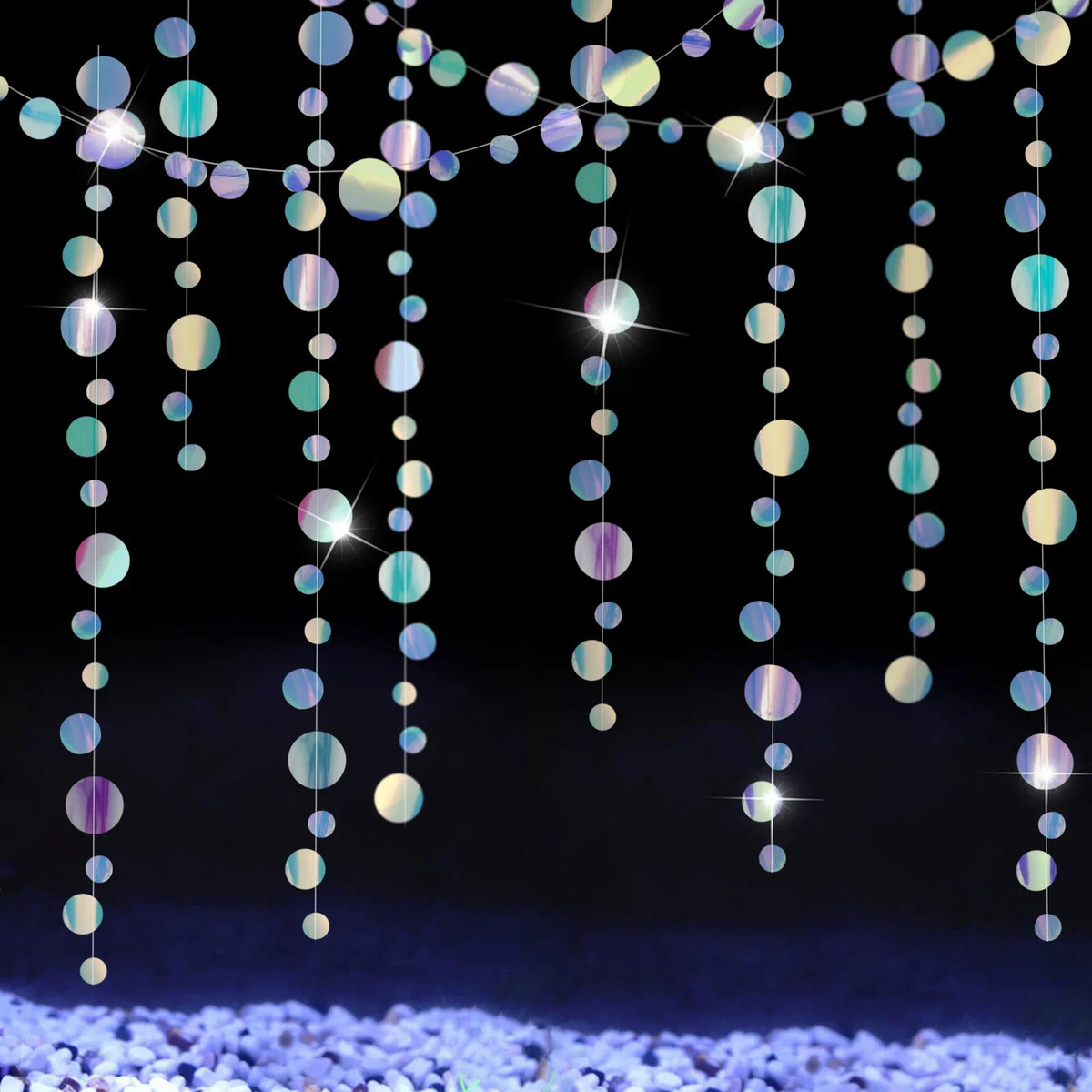 Iridescent mermaid and jellyfish party streamers hanging down over sparkling blue glitter