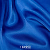 Deep blue satin fabric draped and folded, showing smooth texture and rich color.