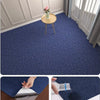 Close-up view of a navy blue self-adhesive runner rug being applied to a brown surface.