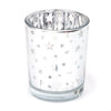 A clear glass votive candle holder decorated with silver stars.