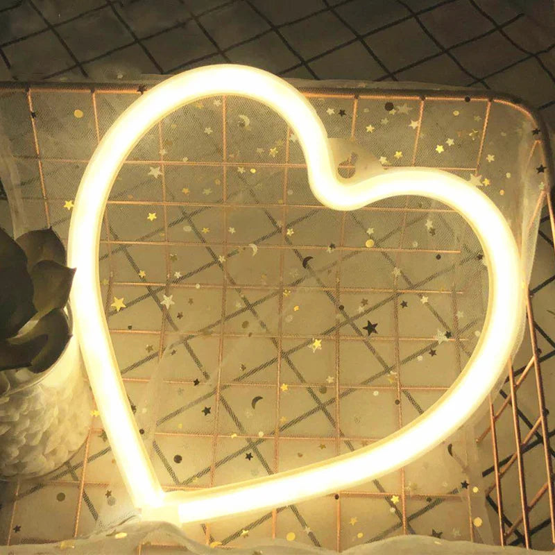 A heart-shaped neon sign with a starry pattern is displayed against a textured wall.