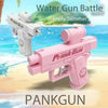 Pink prank gun water gun toy being used for a summer battle on a beach.