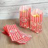 Red and white striped paper popcorn buckets filled with yellow popcorn kernels