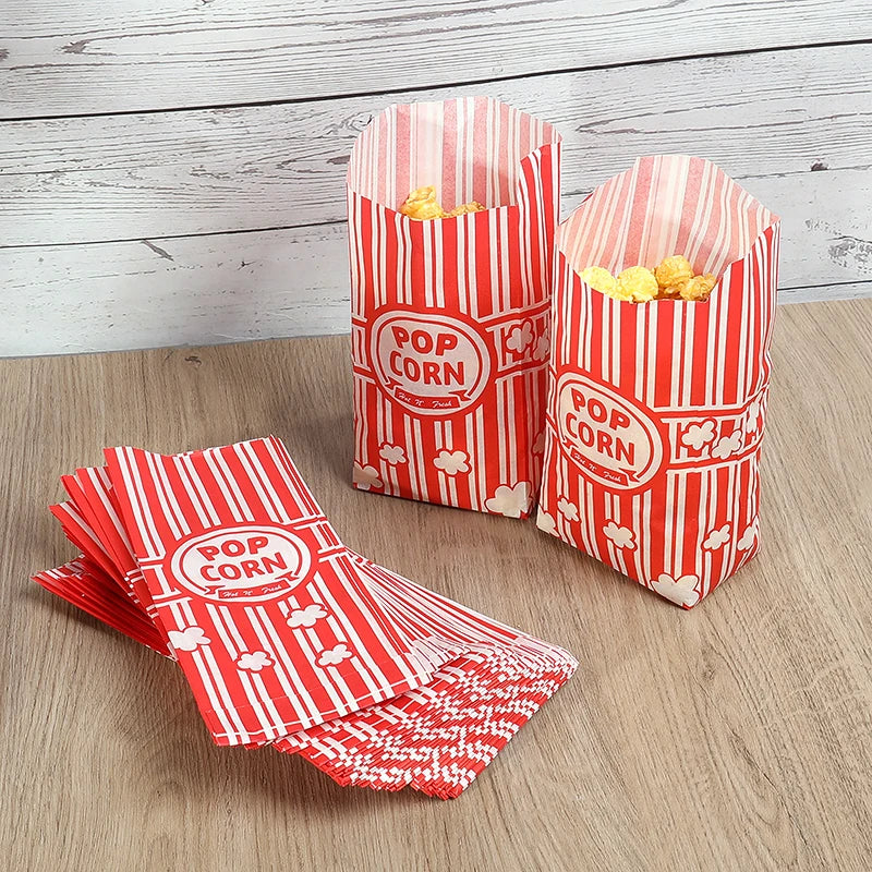 Red and white striped paper popcorn buckets filled with yellow popcorn kernels