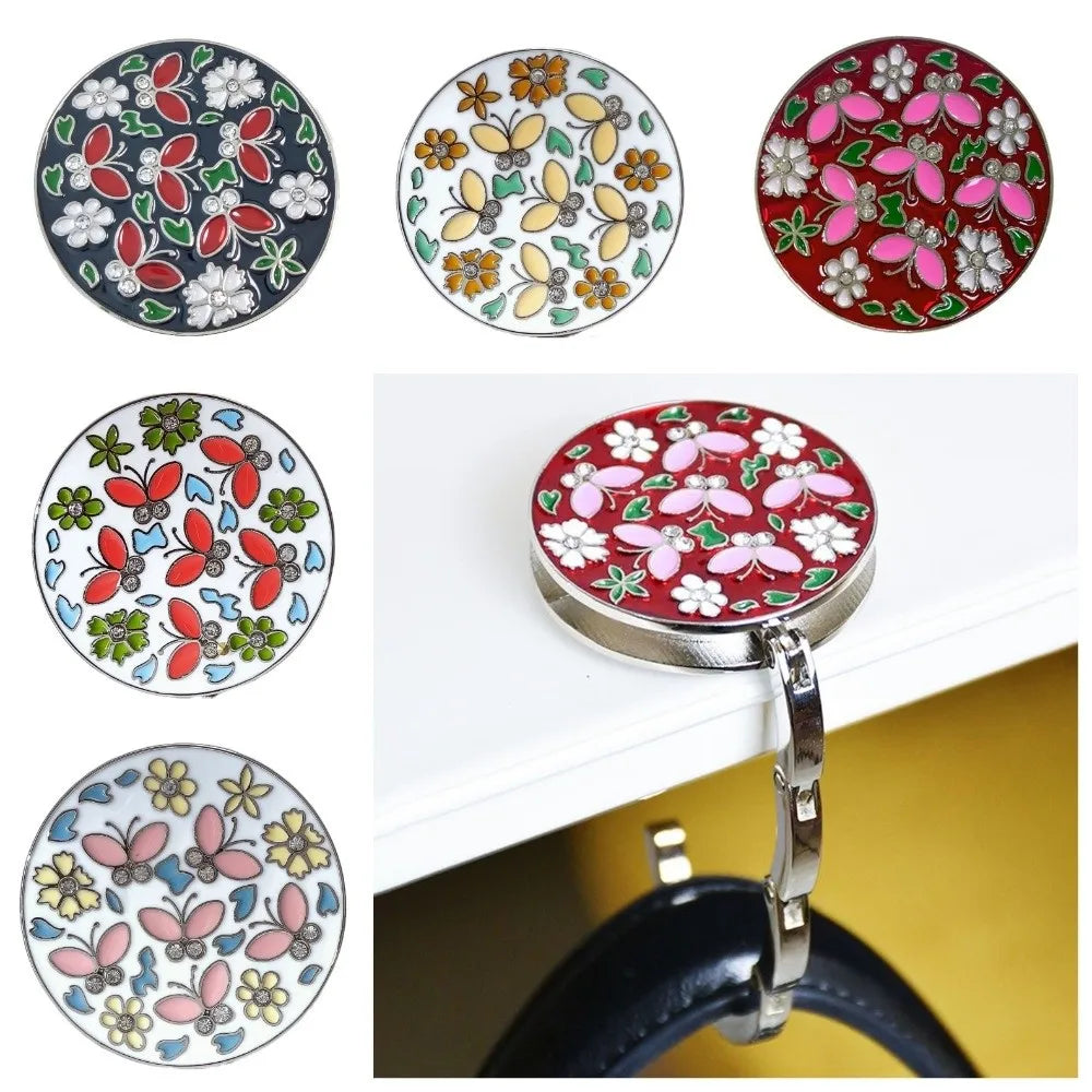 A collection of floral crystal handbag hooks in various colors and designs mounted on a silver metal ring.