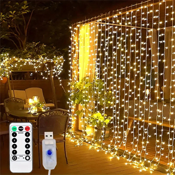A string of warm white LED fairy lights hangs vertically across a wooden deck, illuminating a yellow curtain backdrop.