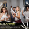 A woman is using a glowing wand for wedding favors in a softly lit indoor setting.