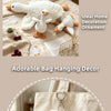 White goose plush keychain pendant with orange feet shown next to a beige fabric bag.