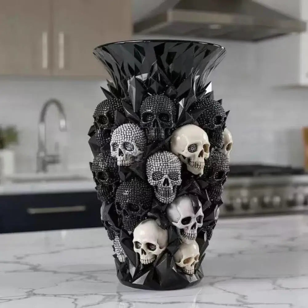 Un vase décoratif noir en forme de crâne, rempli de feuillage et de crânes sombres.