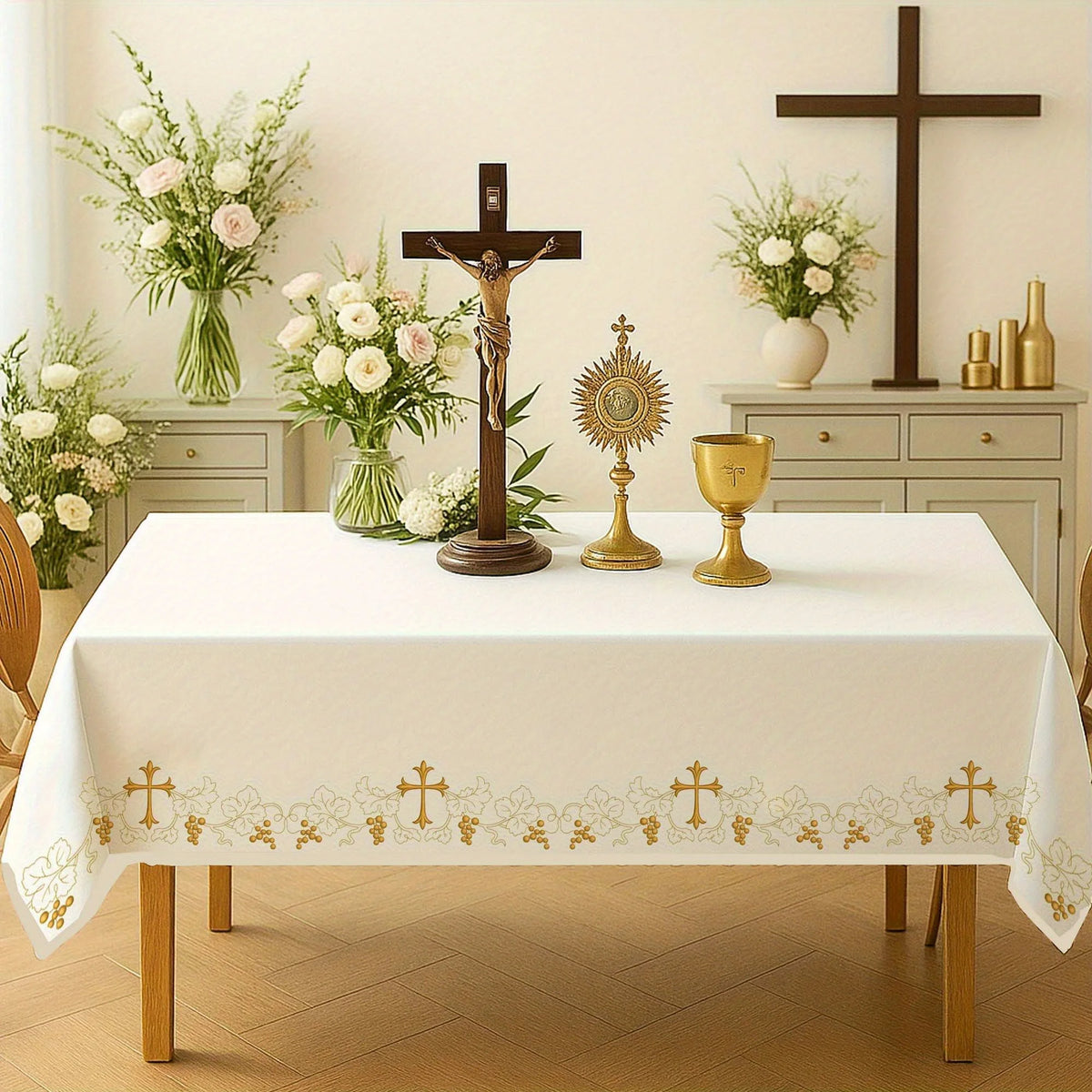 Elegant white and gold church tablecloth displayed on a table with crucifixes and flowers.