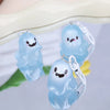 A translucent light blue ghost keychain with a smiling face and a clear plastic charm on a white background.