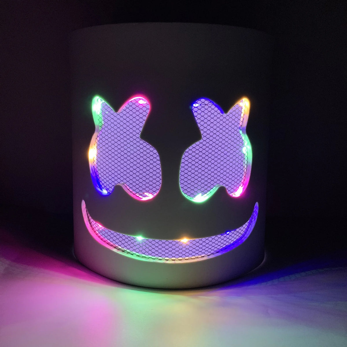 A cylindrical light fixture featuring a glowing neon LED face mask design with flashing purple and green lights.