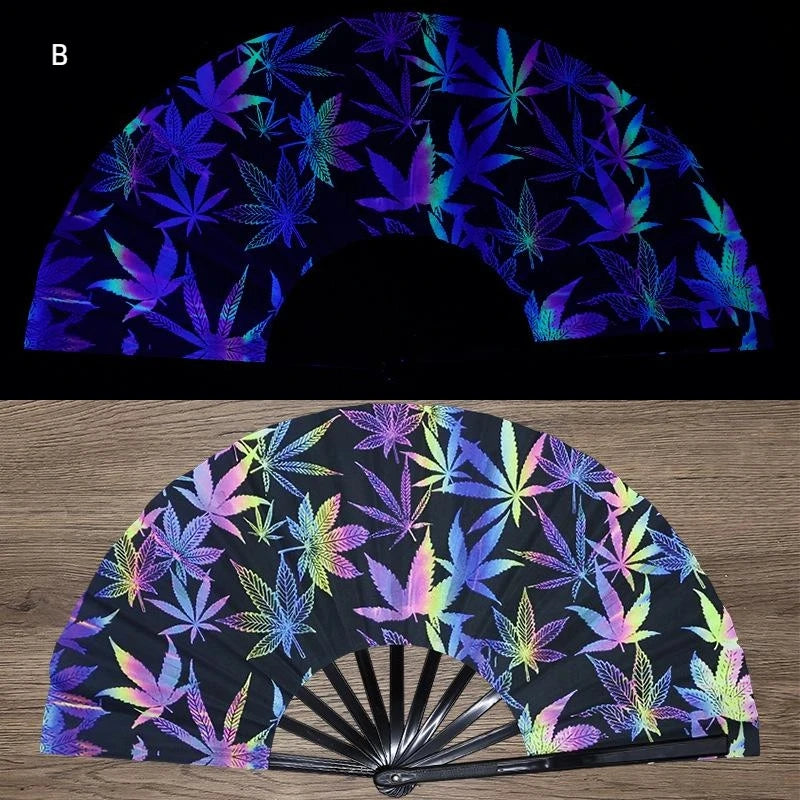 A folding fan featuring a dark background with vibrant UV fluorescent cannabis leaf patterns.