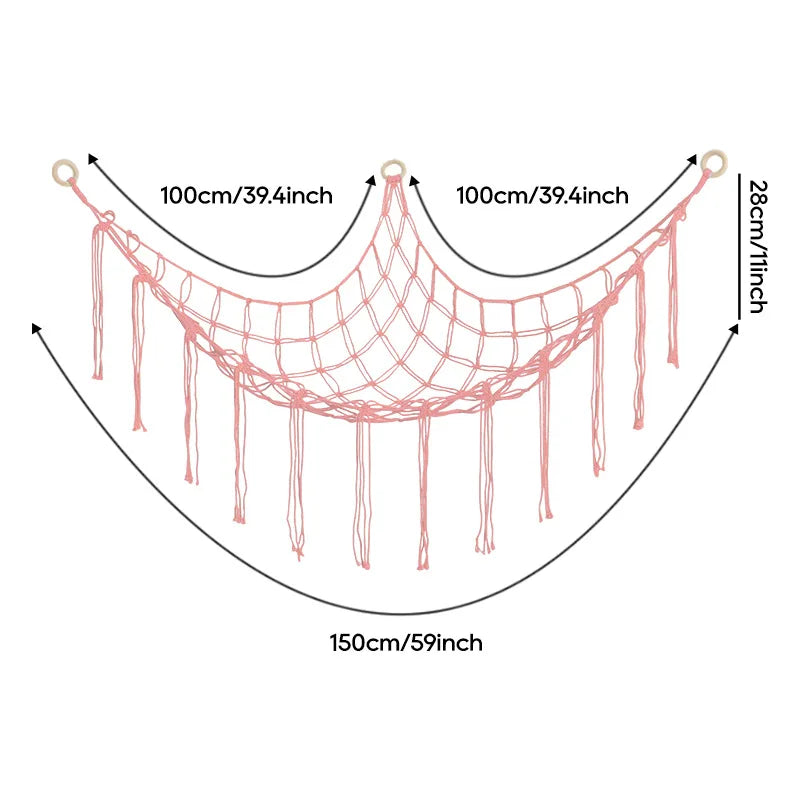 A pink cotton corner toy hammock for stuffed animals and plushies with hanging strands.