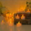 A collection of glowing warm white LED tealight candles arranged on a wooden surface with soft yellow lighting.