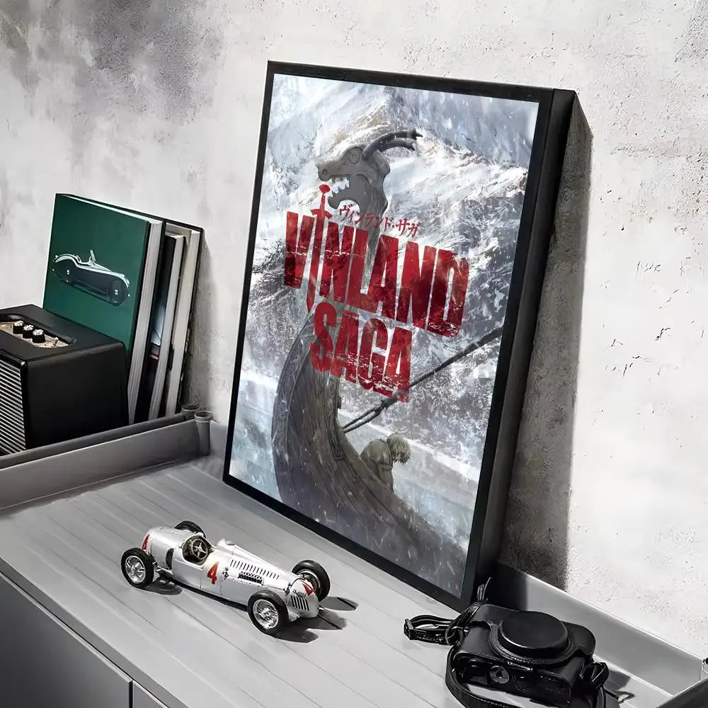 A framed poster of the Vinland Saga anime featuring a warrior on a snowy mountain, displayed on a shelf.