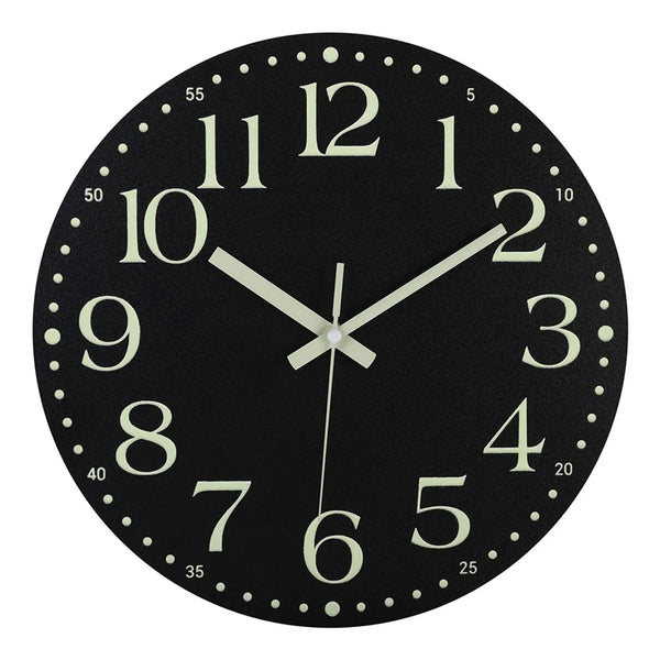 A black wall clock face with white numbers and hands, featuring a glow-in-the-dark design.