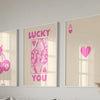 Three framed art prints featuring pink heart designs and the word lucky you on a light background