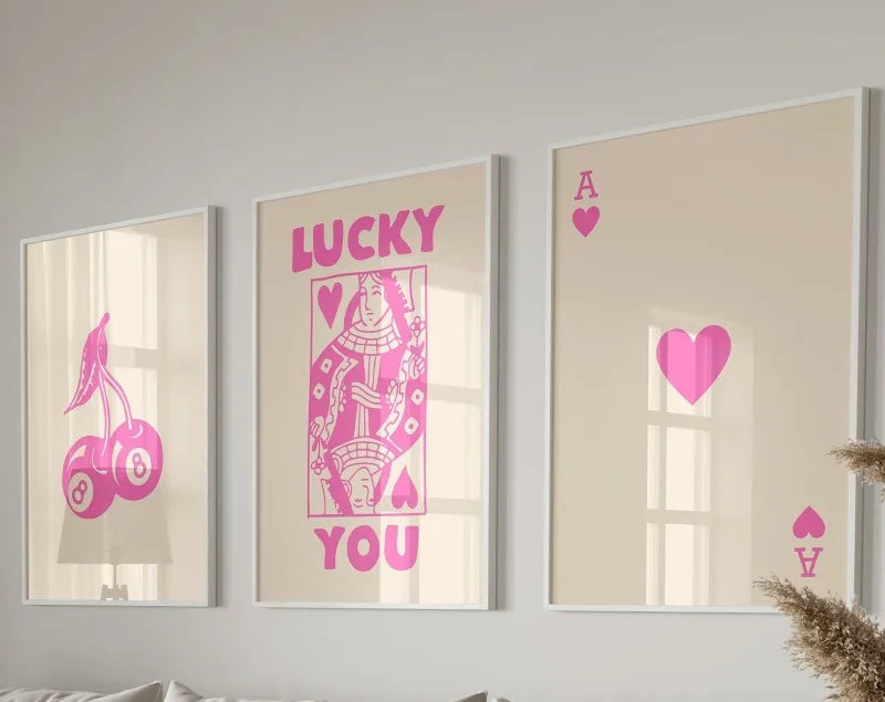 Three framed art prints featuring pink heart designs and the word lucky you on a light background