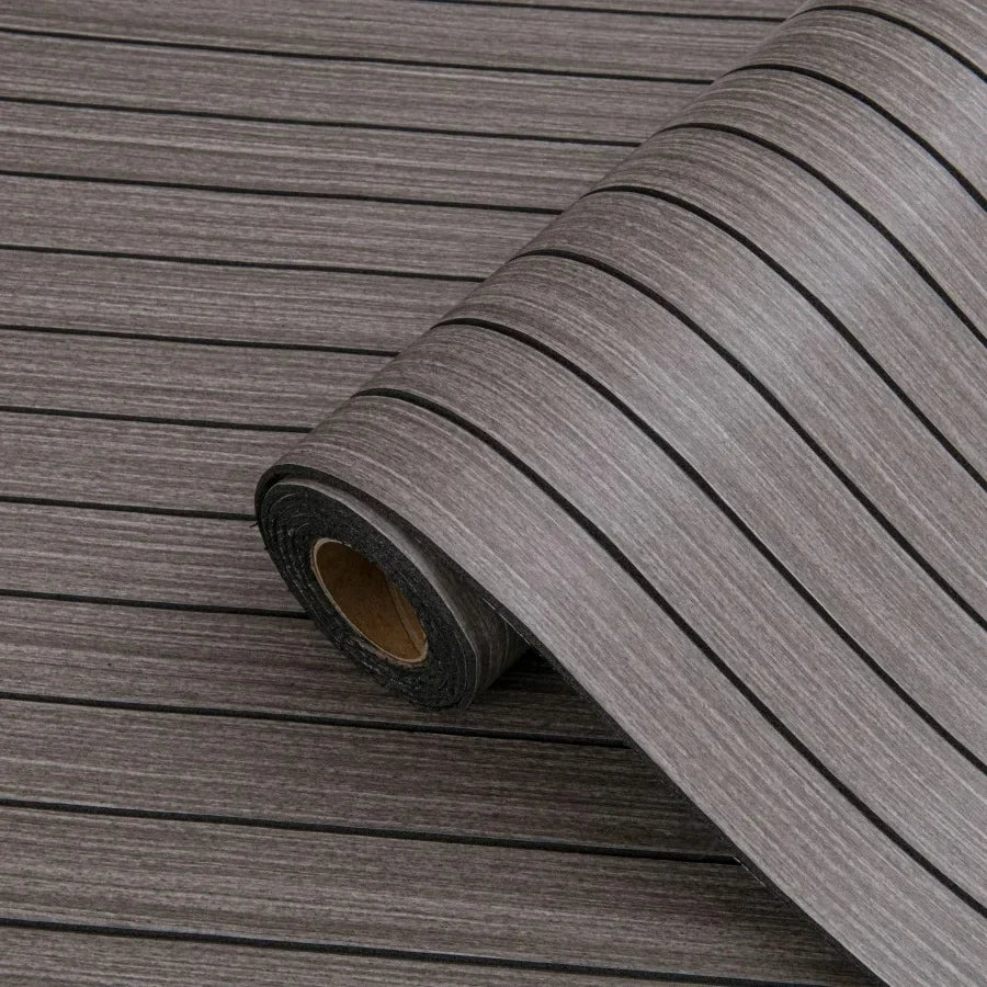 Roll of self-adhesive 3D wood grain wall panels showing a dark gray textured surface.